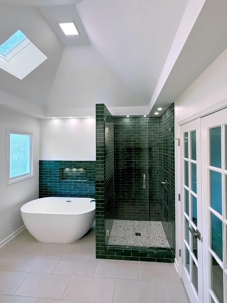 Finished luxury bathroom remodel in Atlanta with green tile shower and freestanding tub by I Want To Renovate